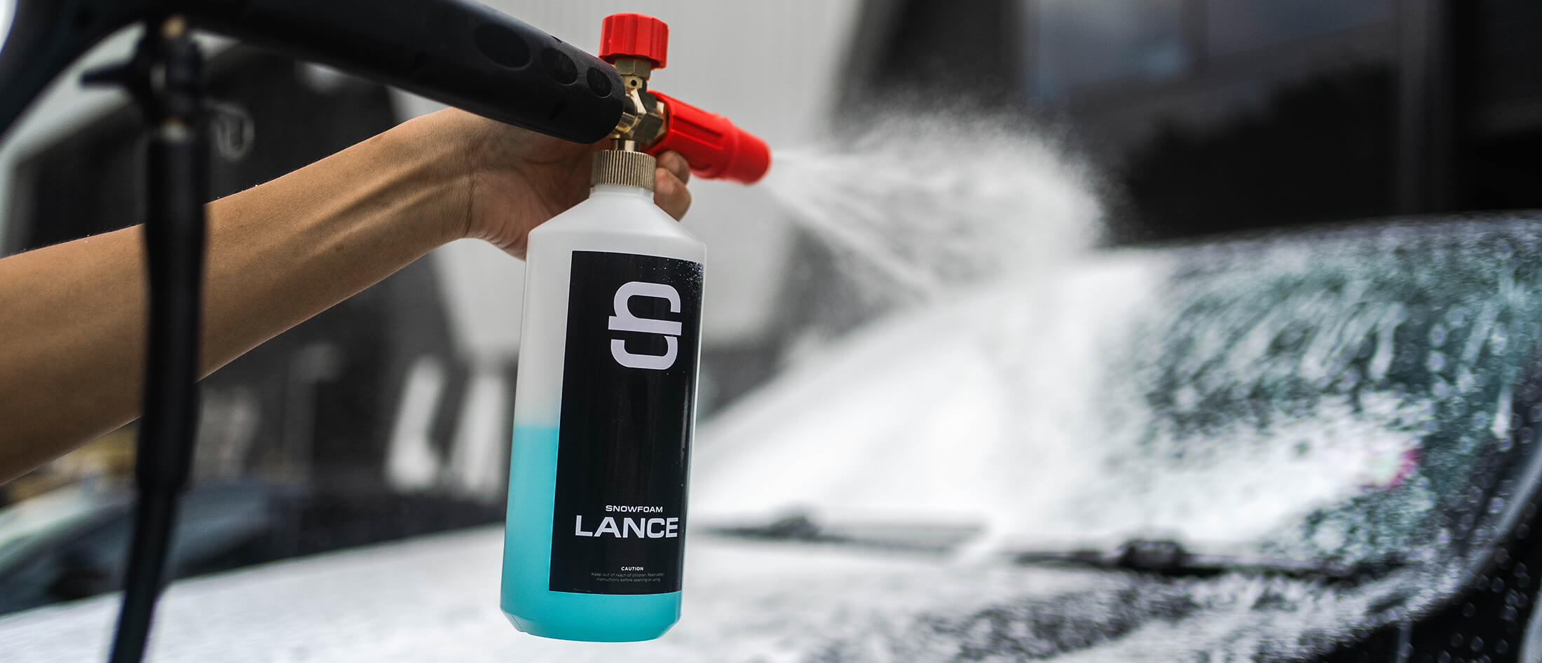 A Snow Foam Lance being used on a car.